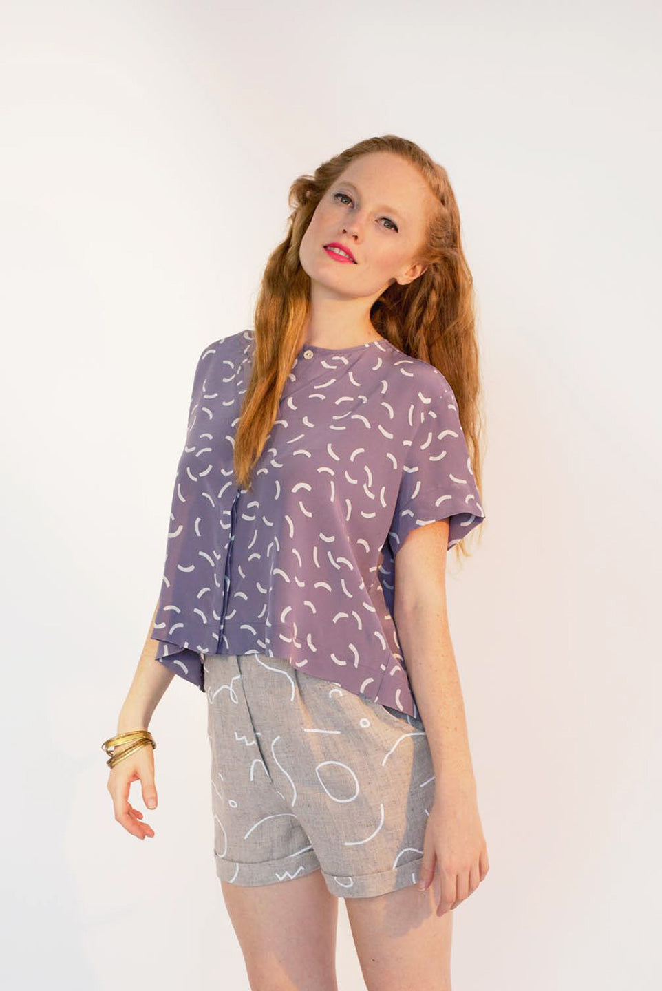 woman in purple shirt with tan shorts line pattern