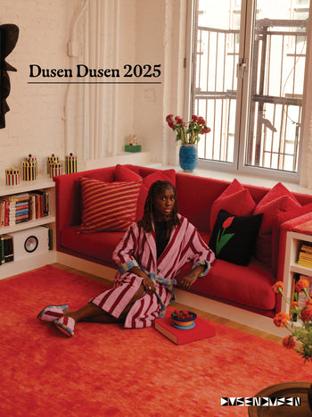 ["Person sitting on a red couch in a stylish room with 'Dusen Dusen 2025' in text above them"]