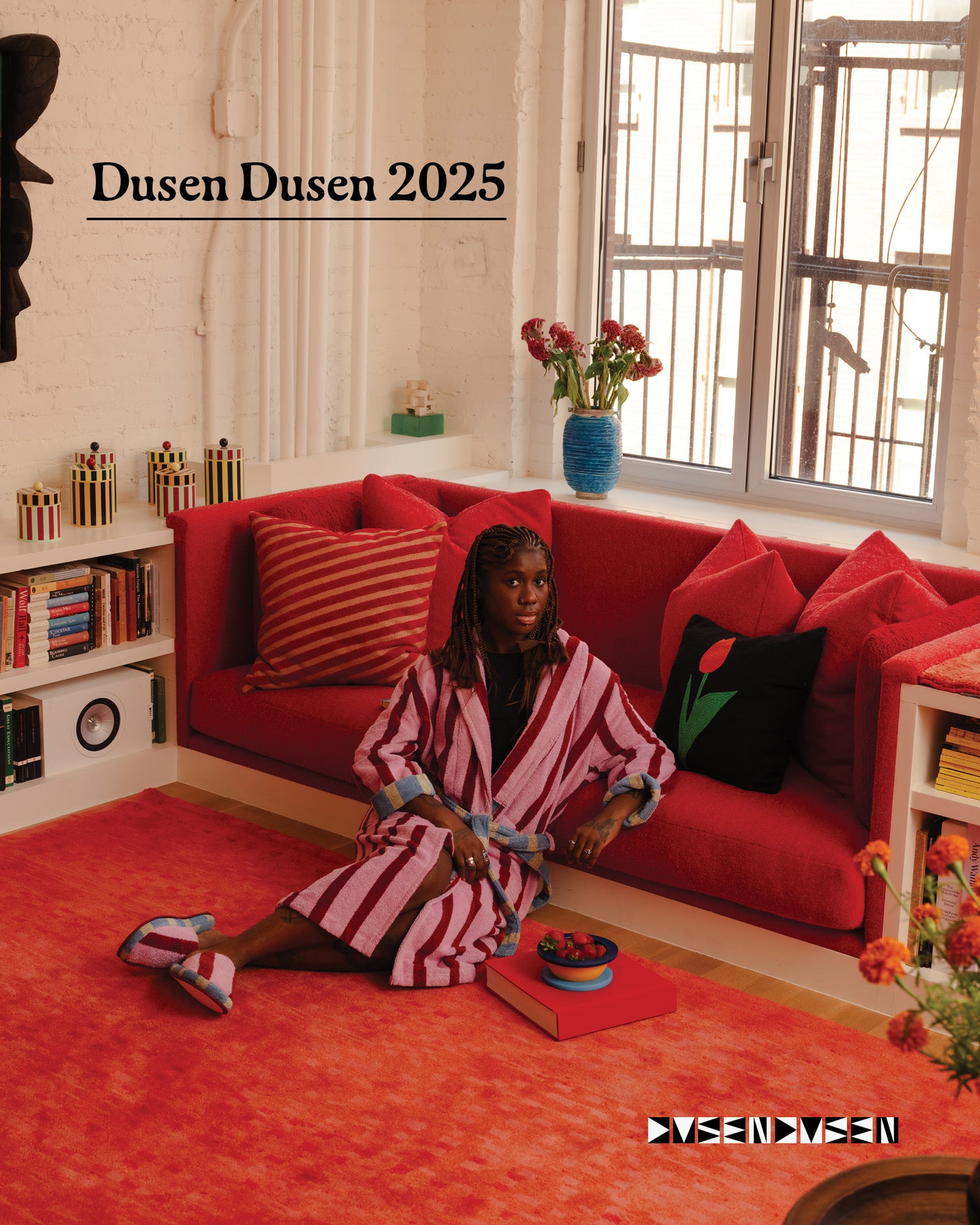 Person sitting on a red couch in a stylish room with 'Dusen Dusen 2025' in text above them