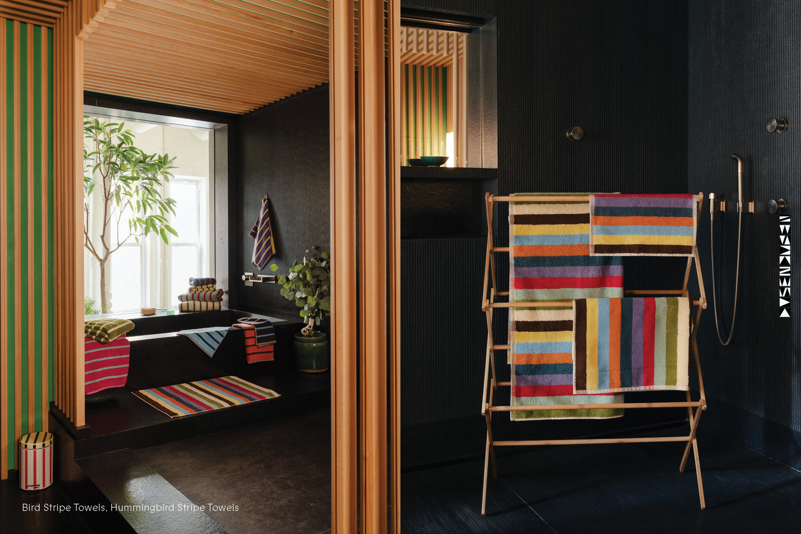 Colorful striped towels on a rack in a black stone bathroom and Bird Stripe towels scattered around a black tub
