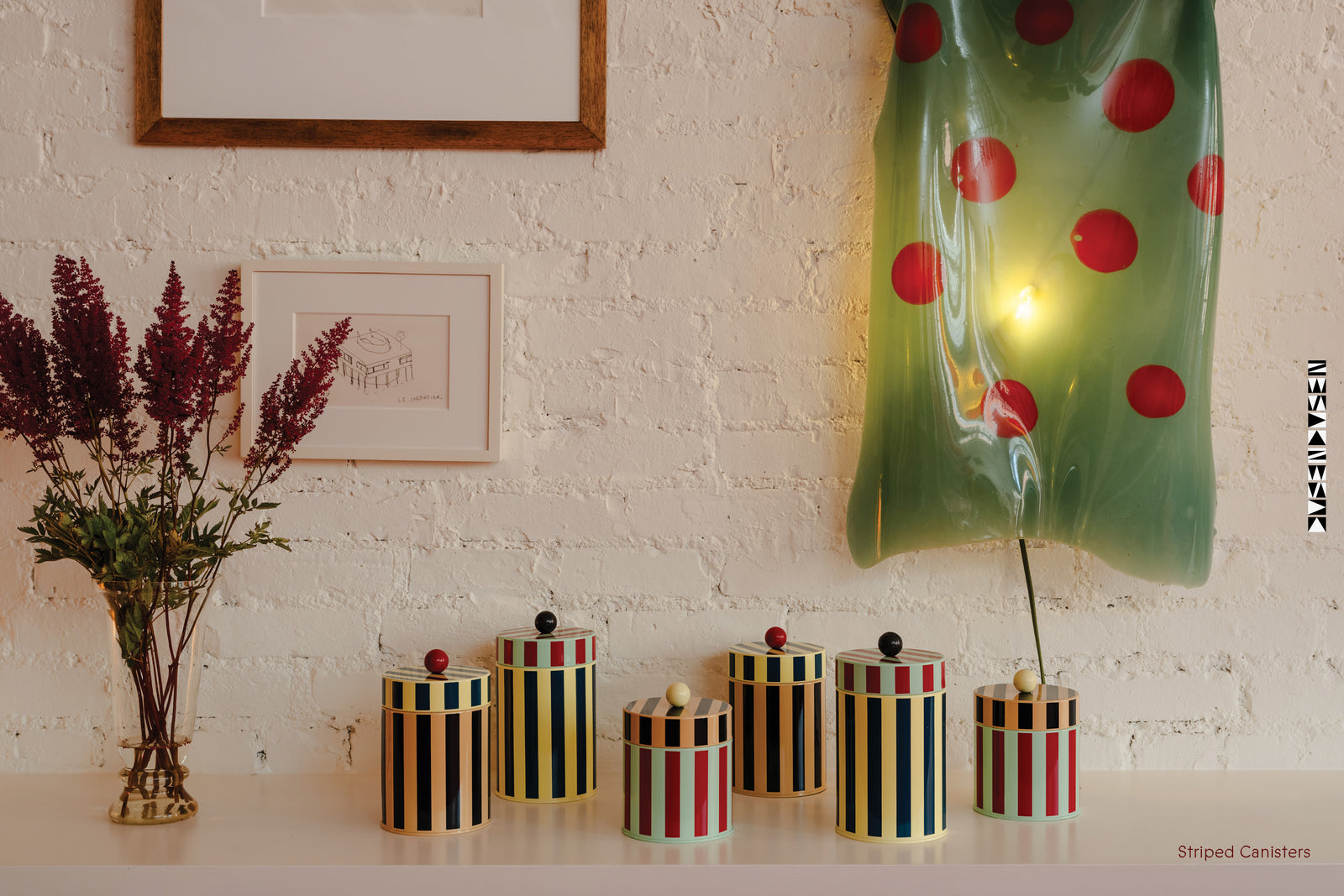 Canisters on a shelf with flowers and Gaetano Pesce lamp