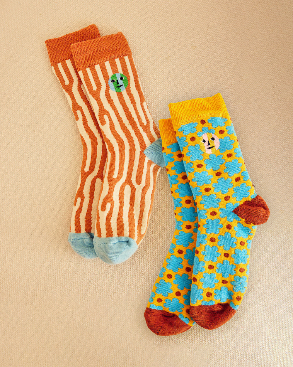 Two pairs of socks with different patterns on a beige background