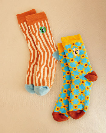 Two pairs of socks with different patterns on a beige background