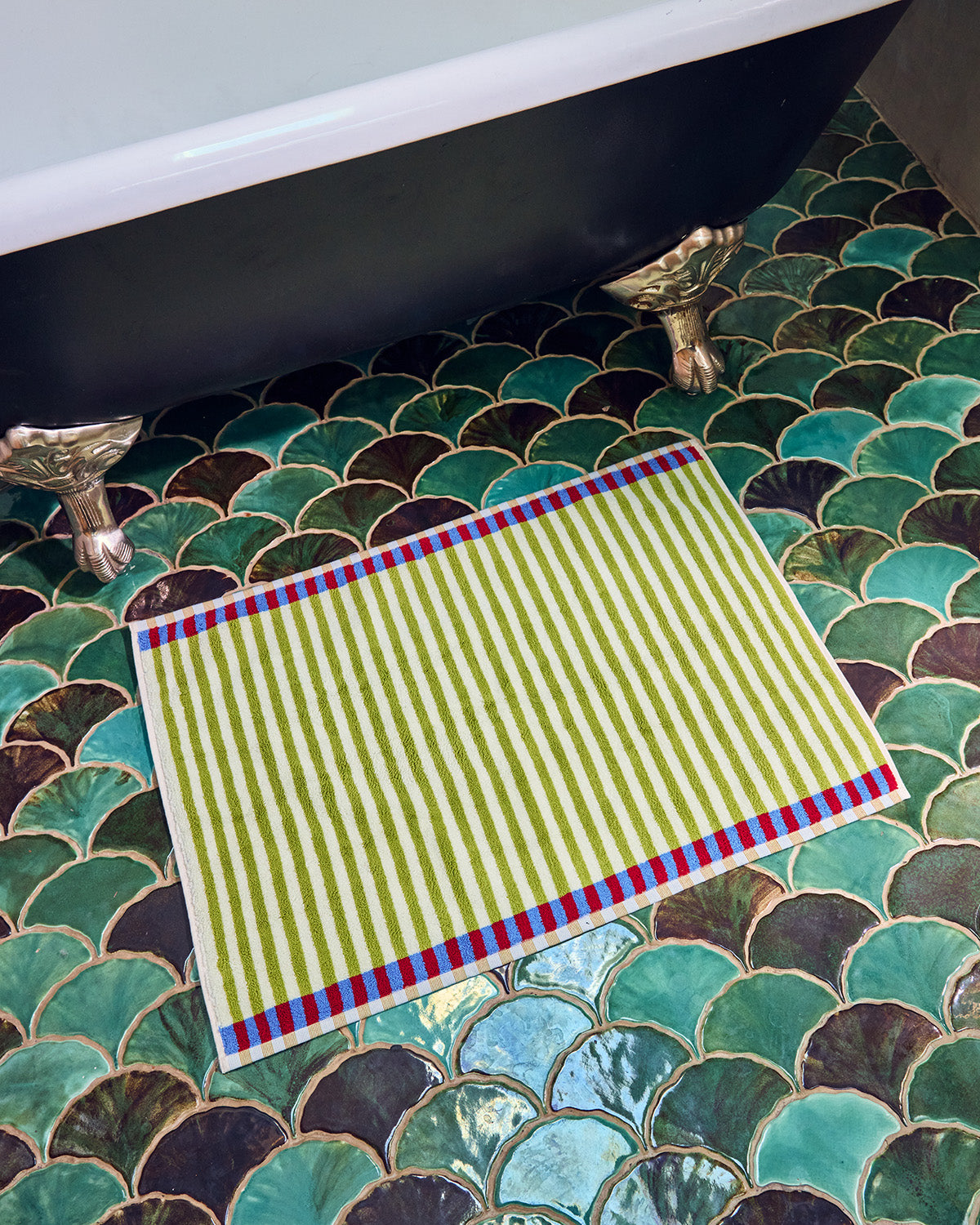 Green striped towel on a decorative tiled bathroom floor