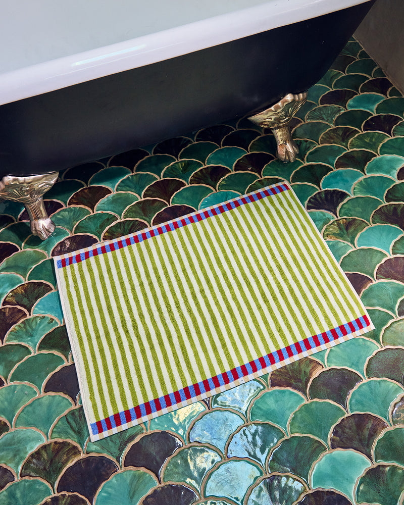 Green striped towel on a decorative tiled bathroom floor