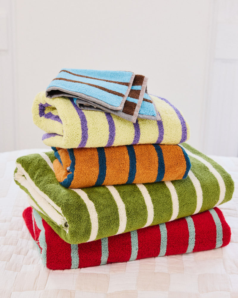 Stack of colorful striped towels on a white surface