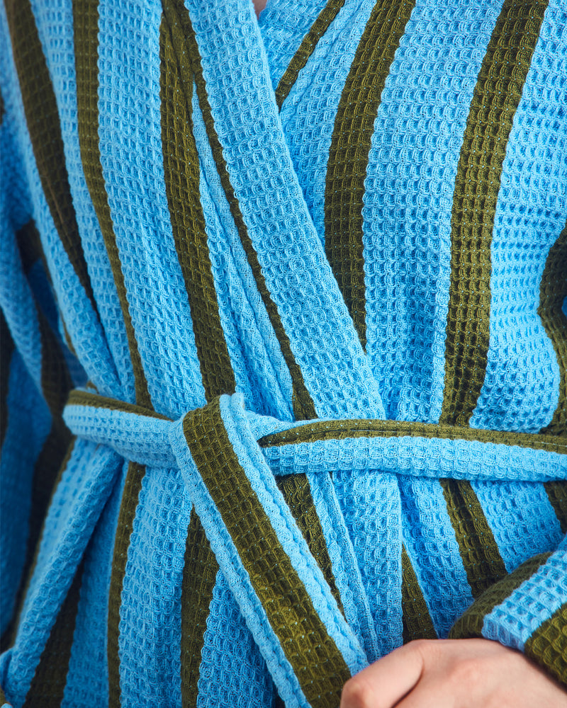 Close-up of a blue and green striped waffle robe with a textured pattern.