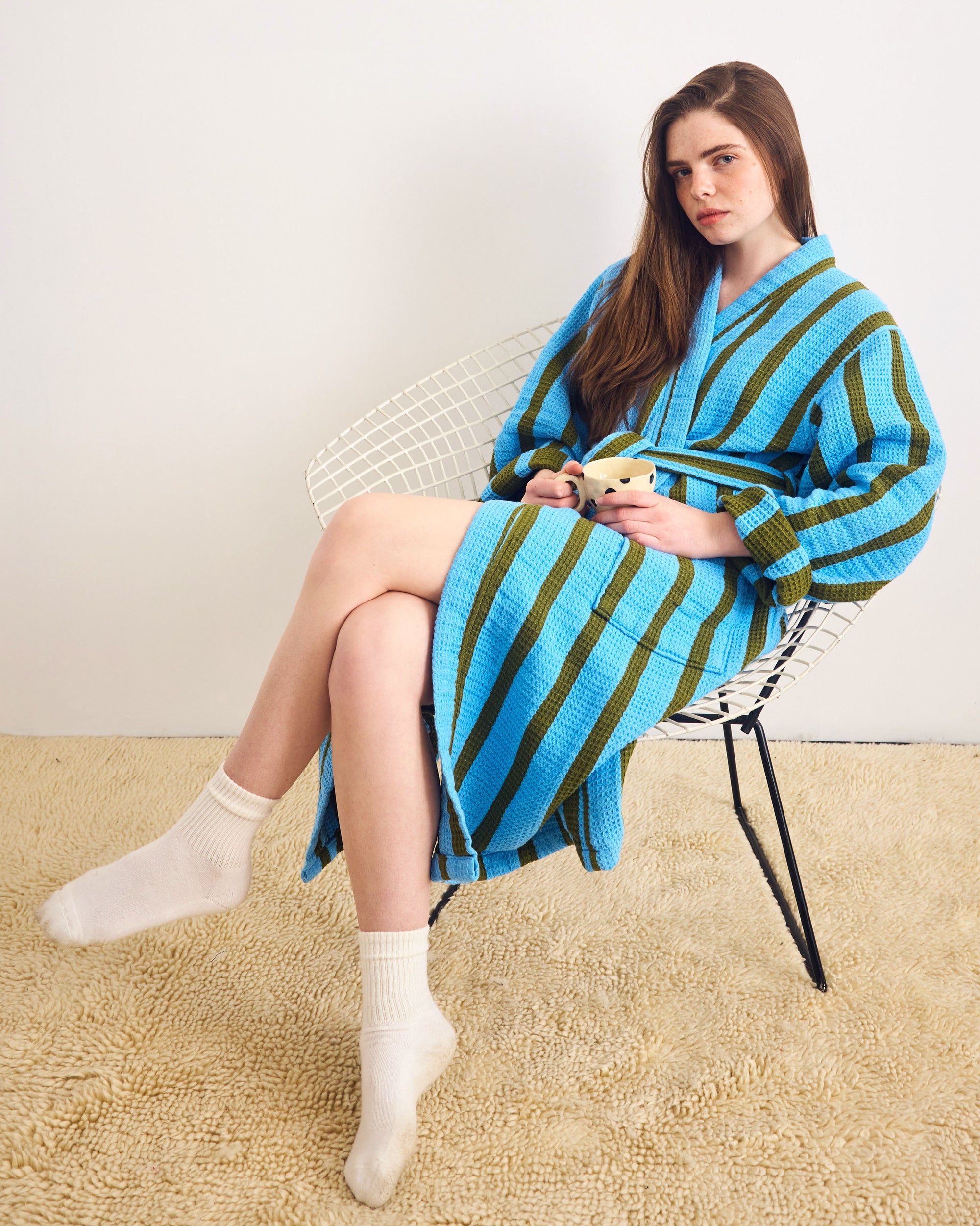 Woman sitting on a chair wearing a blue and green striped robe.; Cool Bathrobe. Need we say more? <br> <br> Erin is 5'8" and wears a size M 
