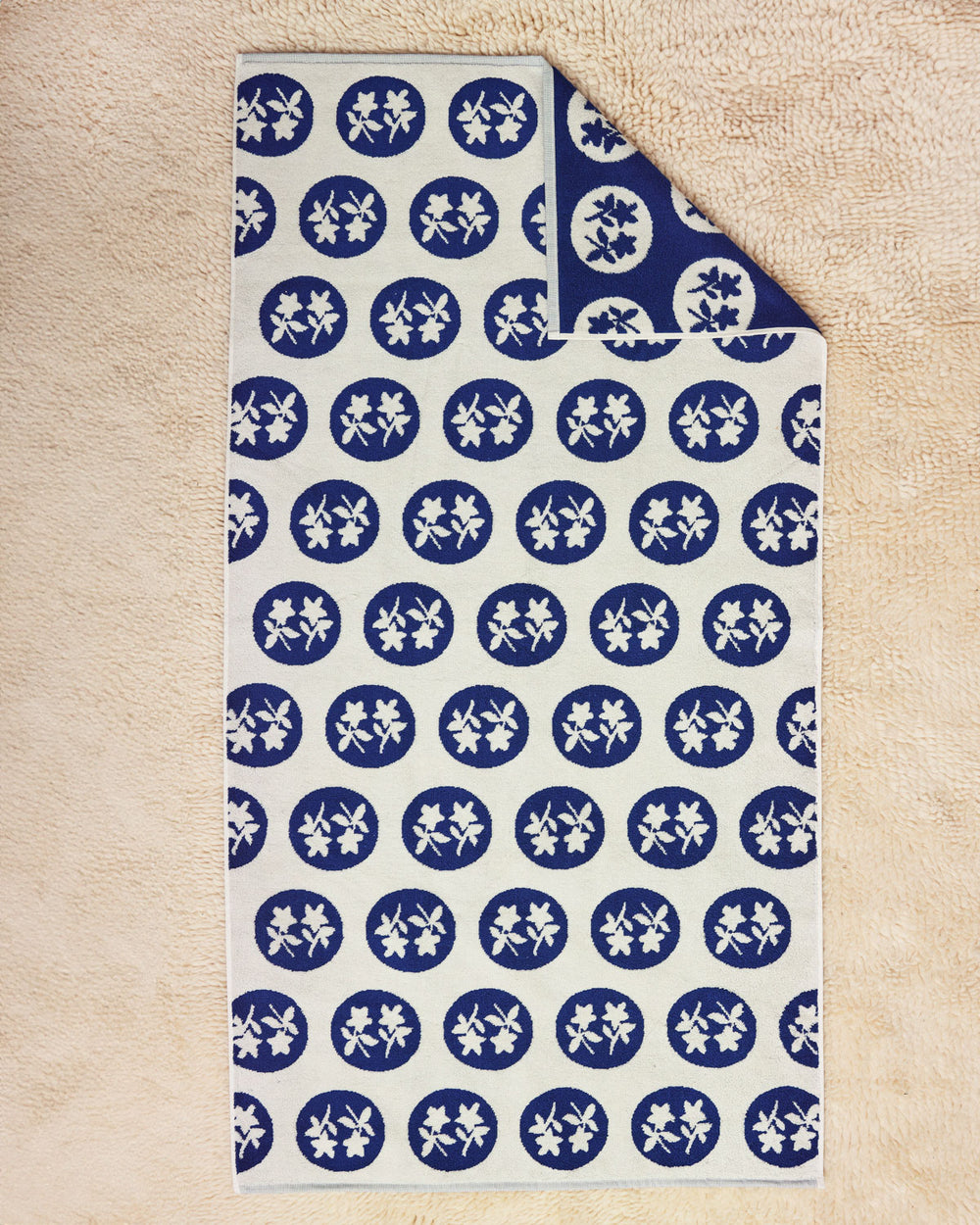 Bouquet Towel flat on a cream rug 