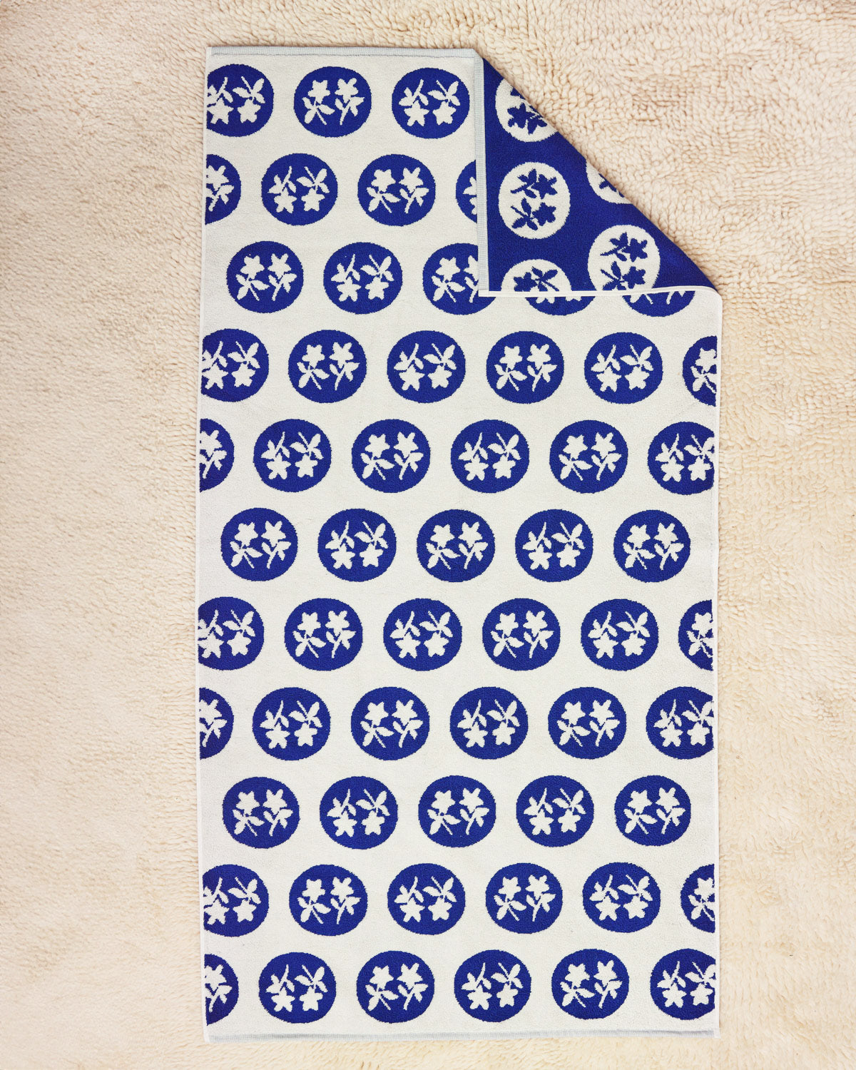 Bouquet Towel flat on a cream rug 
