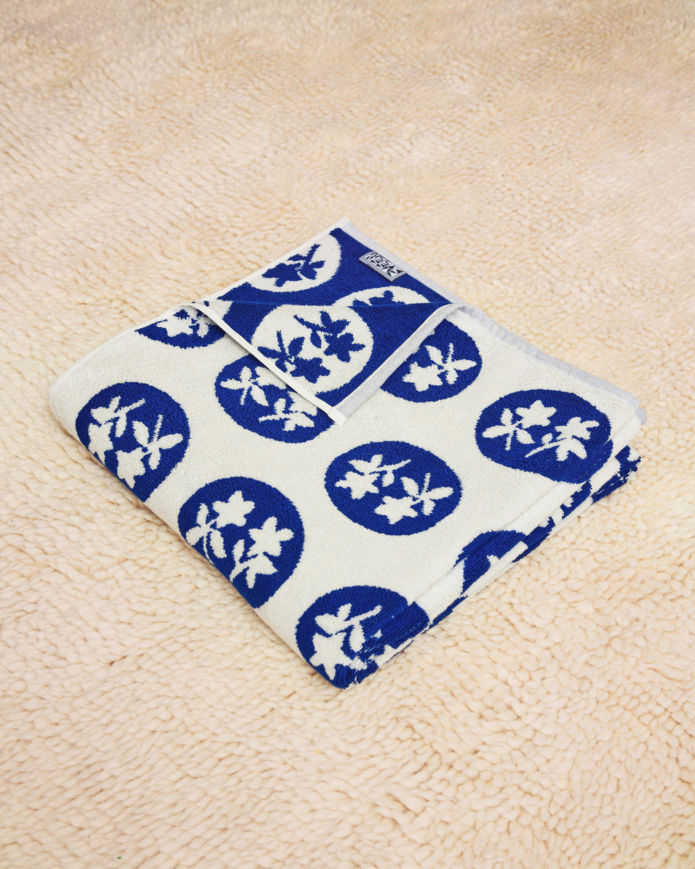 Bouquet Towel folded on a cream rug 