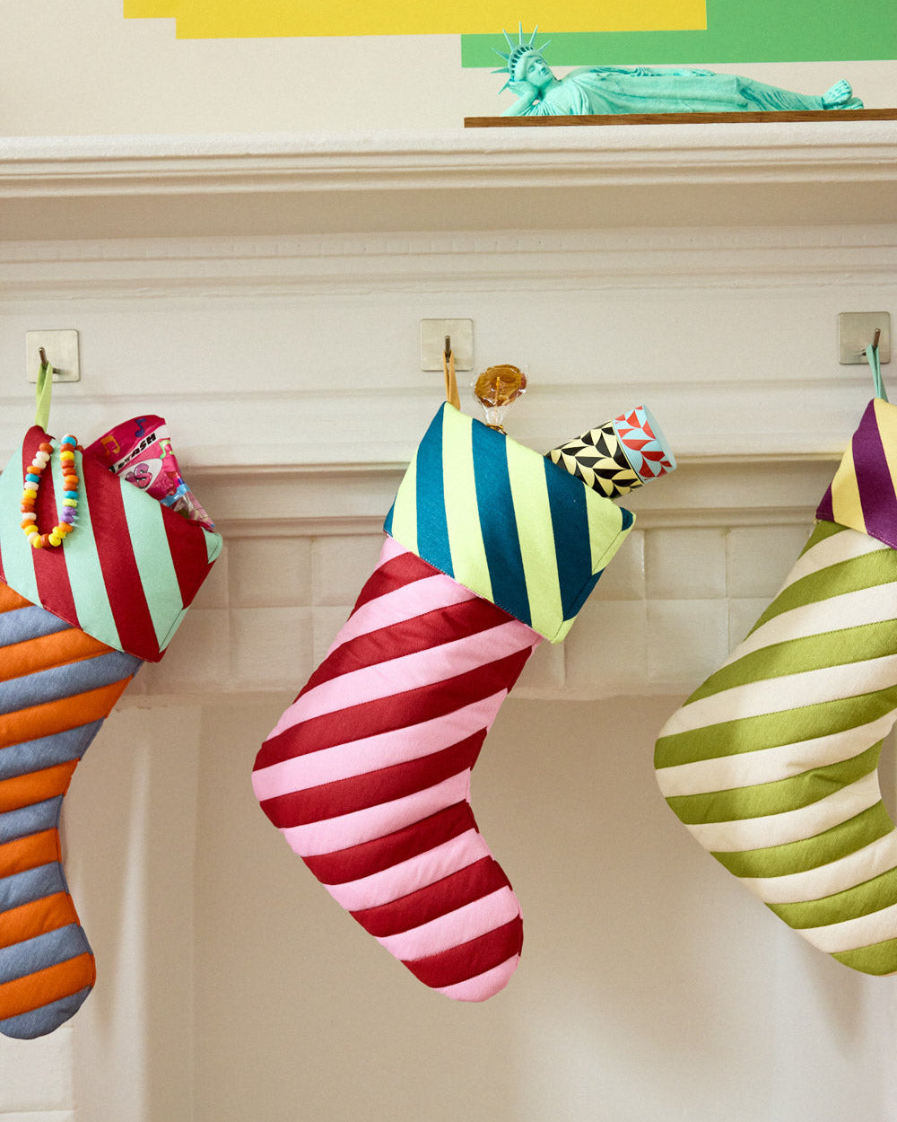 pink and red striped stocking in mantle with insulated bottle coming out of the top
