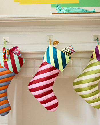 pink and red striped stocking in mantle with insulated bottle coming out of the top