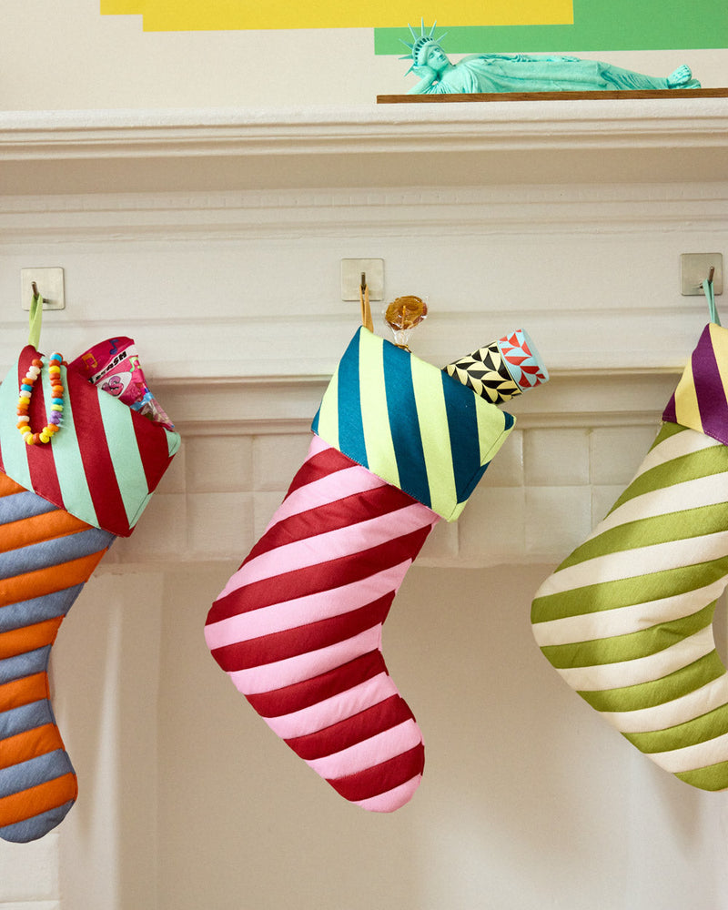 pink and red striped stocking in mantle with insulated bottle coming out of the top