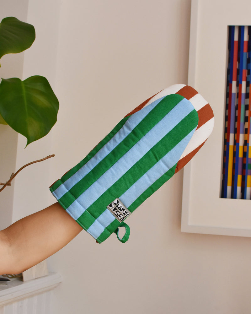 Dusen Dusen Broccoli Oven Mitt. Padded oven mitt in varying stripe weights and contrasting stripe colorways. Features a "frog-style" mitt shape, top stitched brand label, and a side loop. 100% cotton quilted canvas base, with polyester fill.