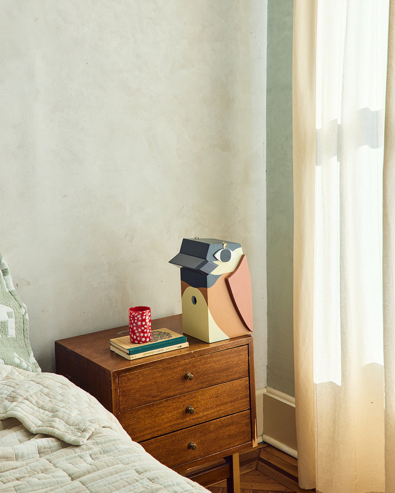 Brown birdhouse on nightstand in light room