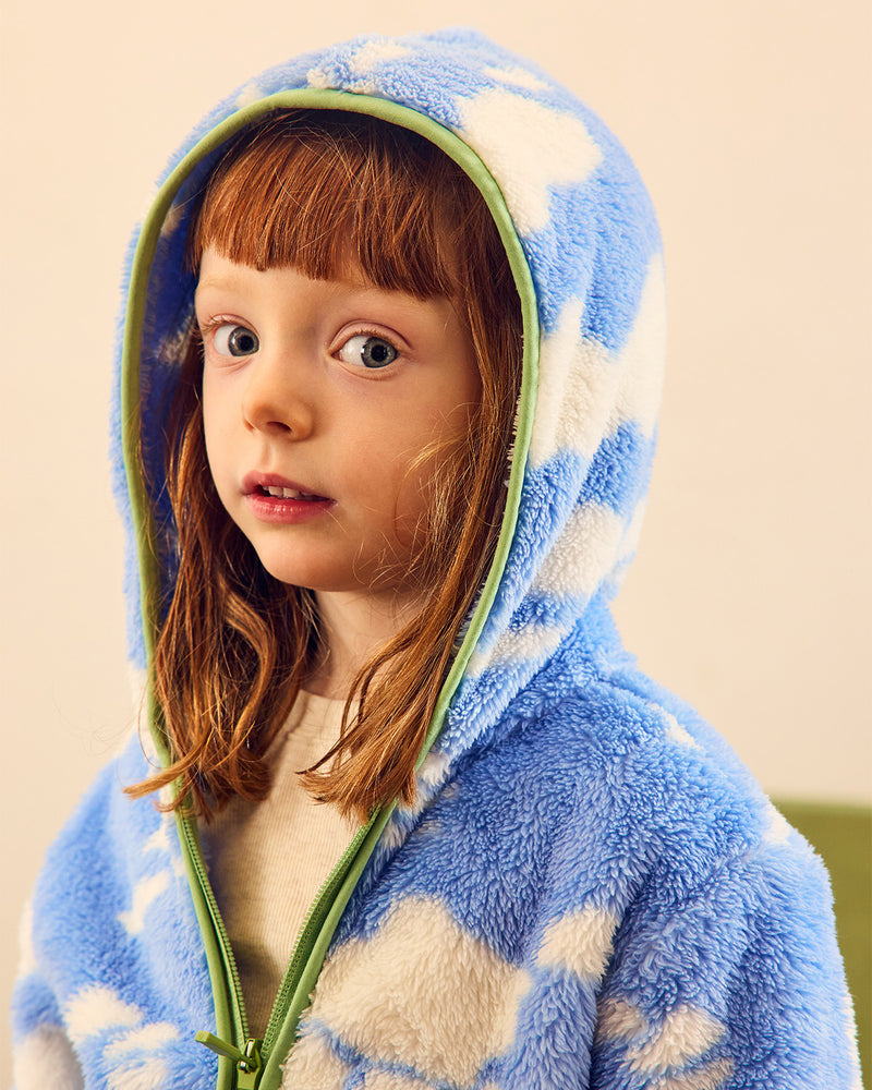blue and white fleece with green trim on red head girl looking at camera