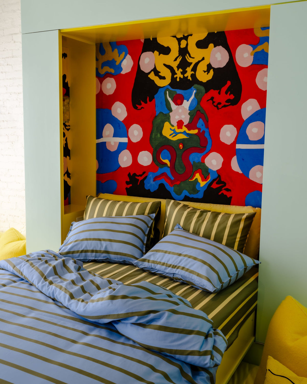 Bedroom with colorful abstract wall art and striped bedding
