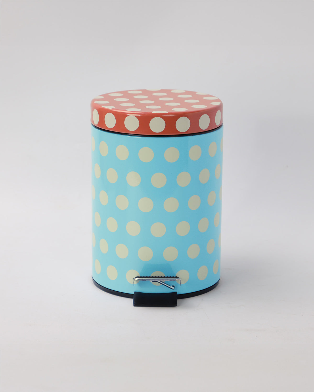 Round trash bin with polka dot design on a light gray background