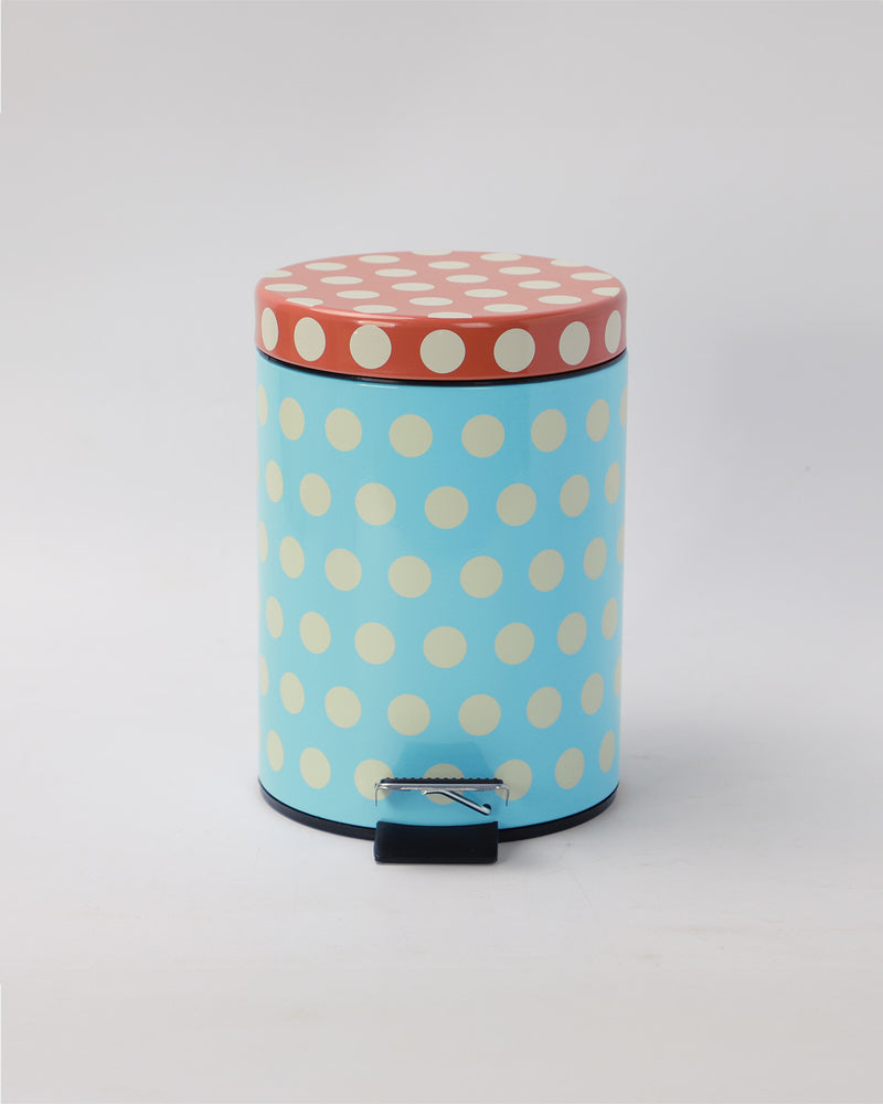 Round trash bin with polka dot design on a light gray background
