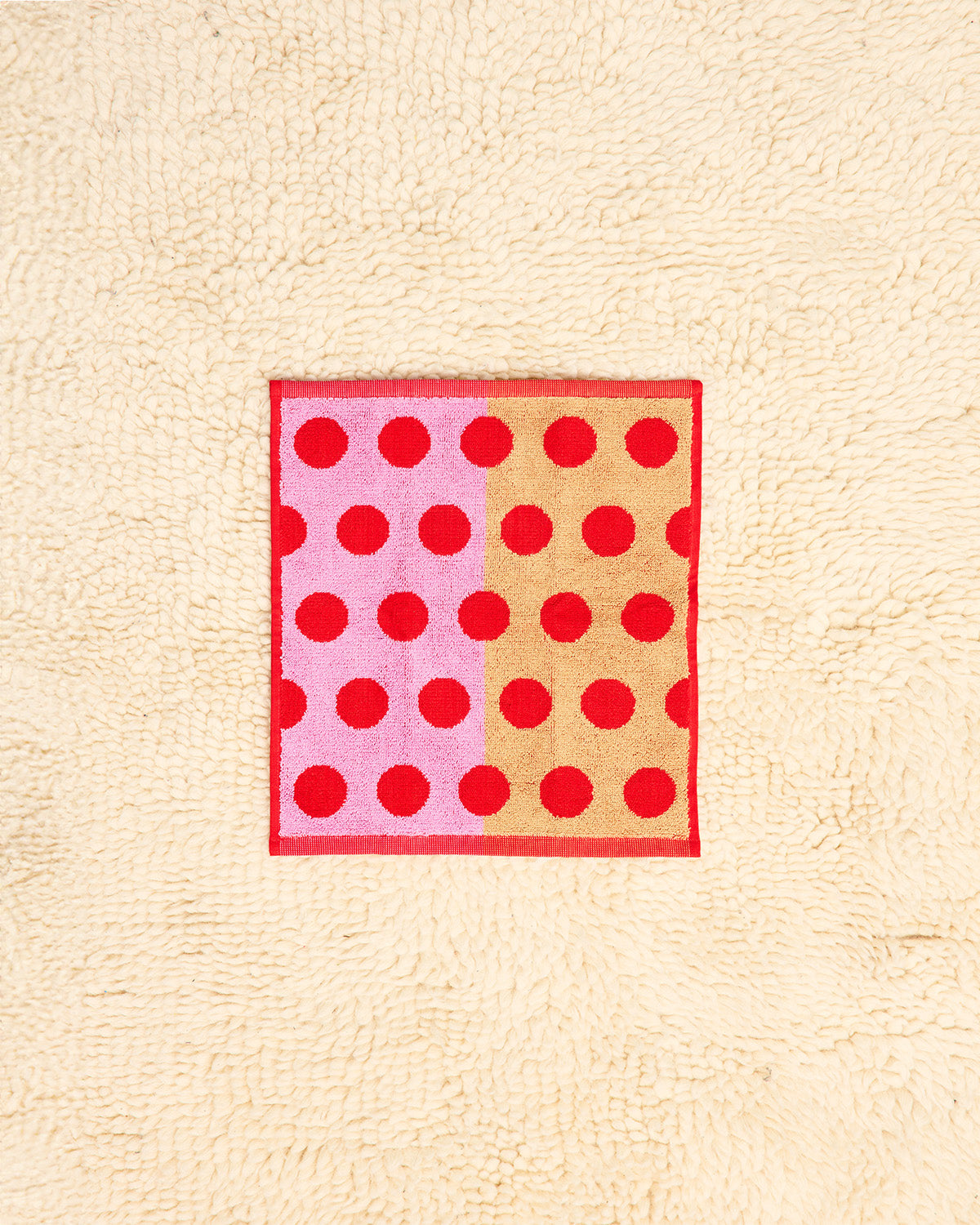 Washcloth with red polka dots on a beige background