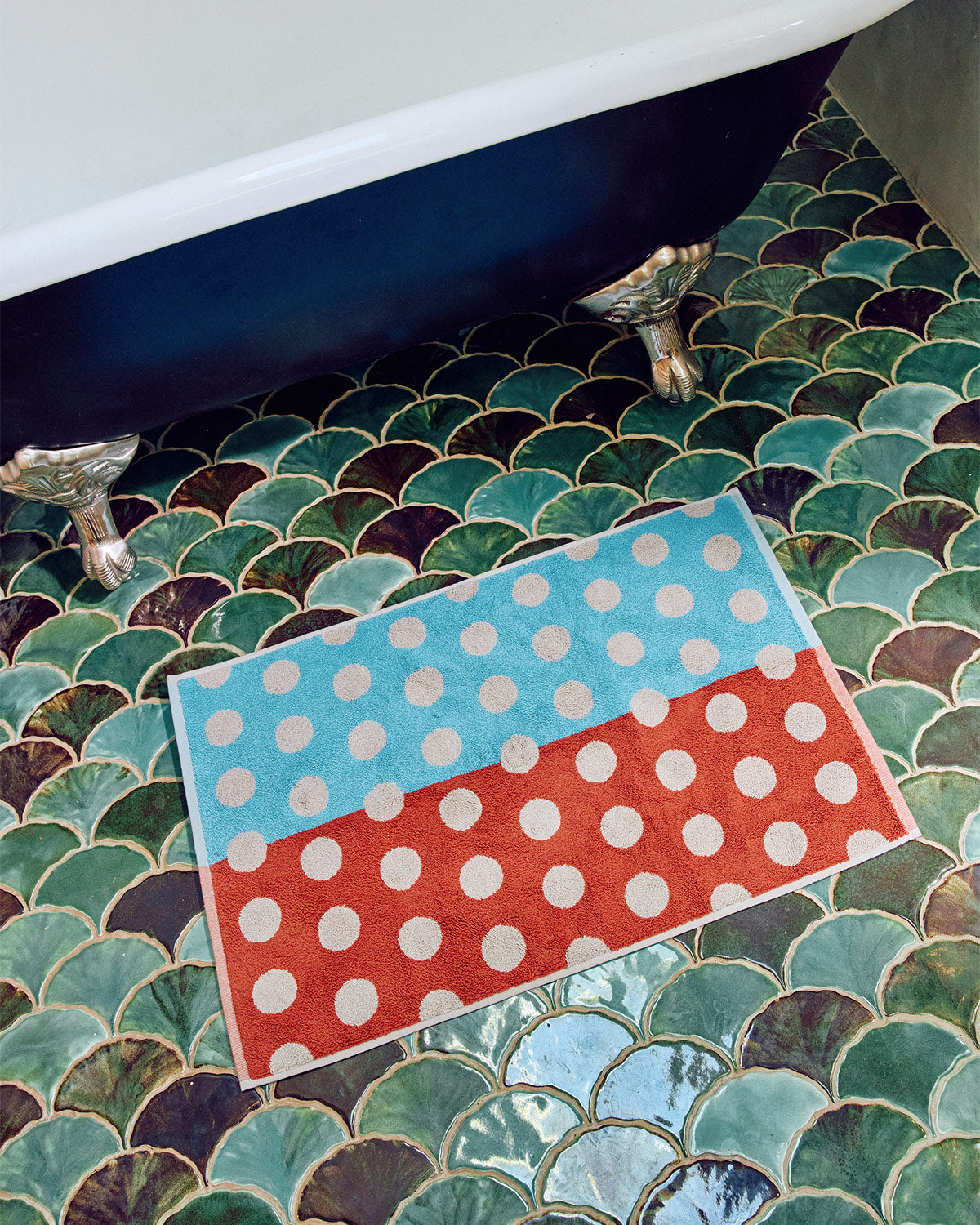 Polka dot rug on a tiled bathroom floor with a bathtub. ;Your cats can play Twister (they won’t know the difference, they’re colorblind)