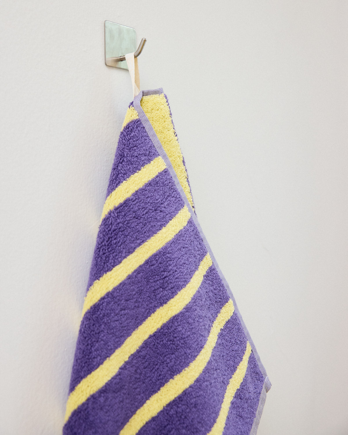 yellow and purple striped towel hanging by hook
