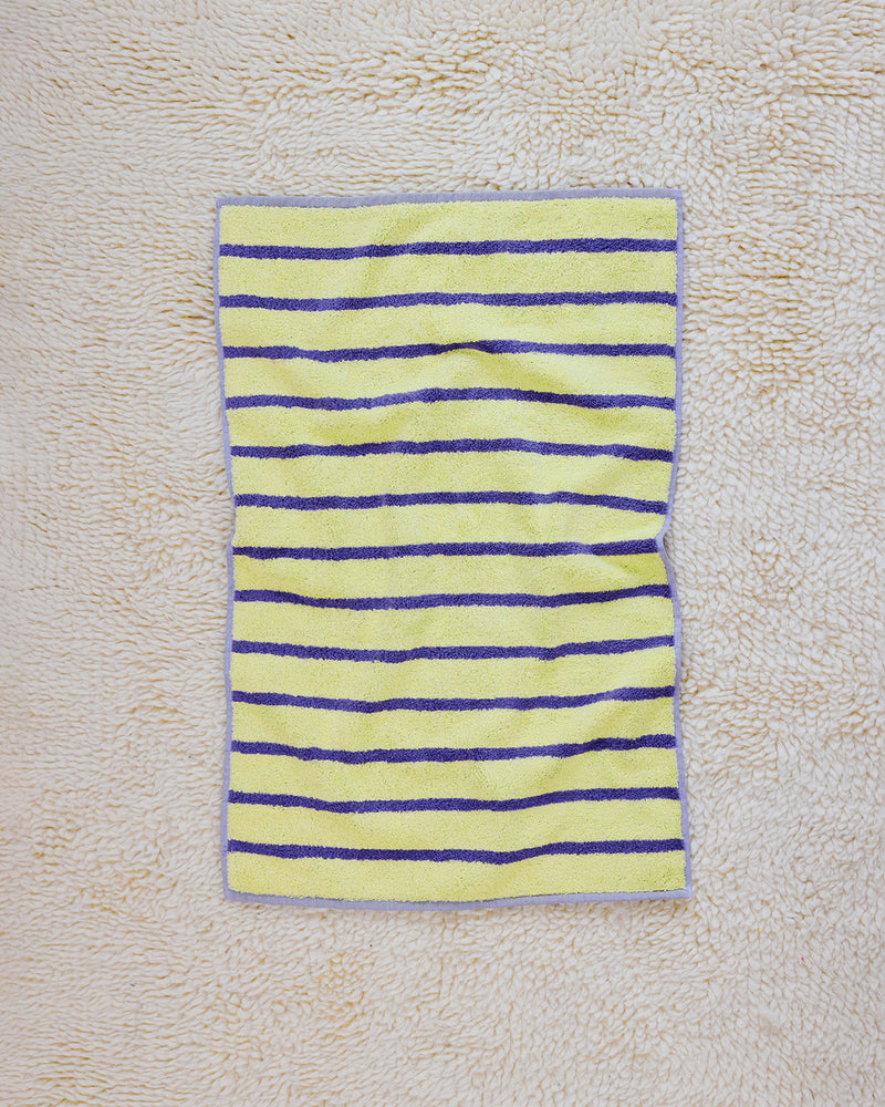 yellow and purple striped towel on rug 