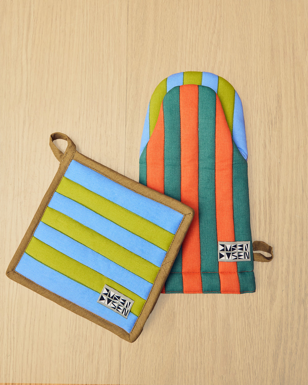 Striped pot holder and oven mitt on a wooden surface