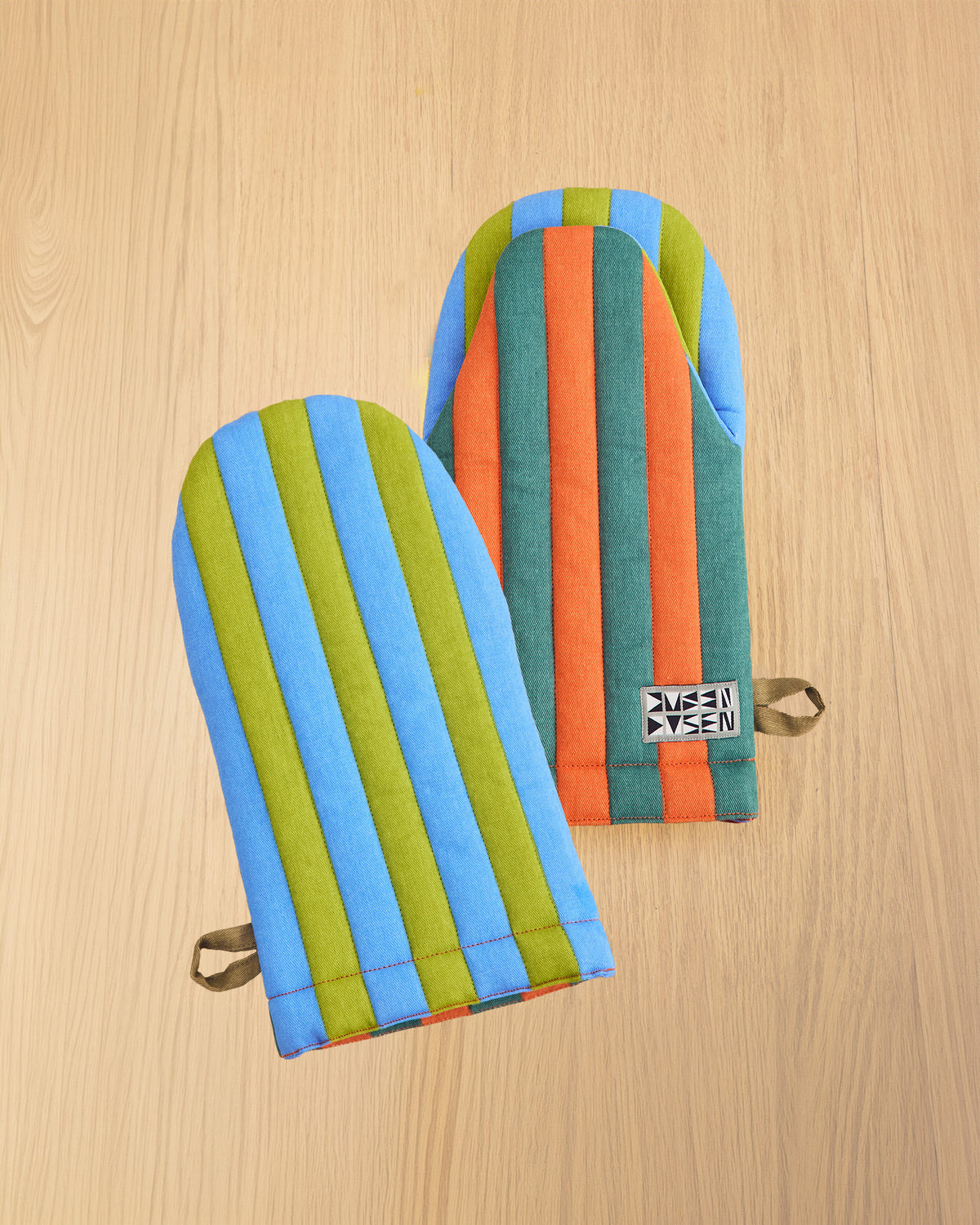 Colorful oven mitts on a beige background