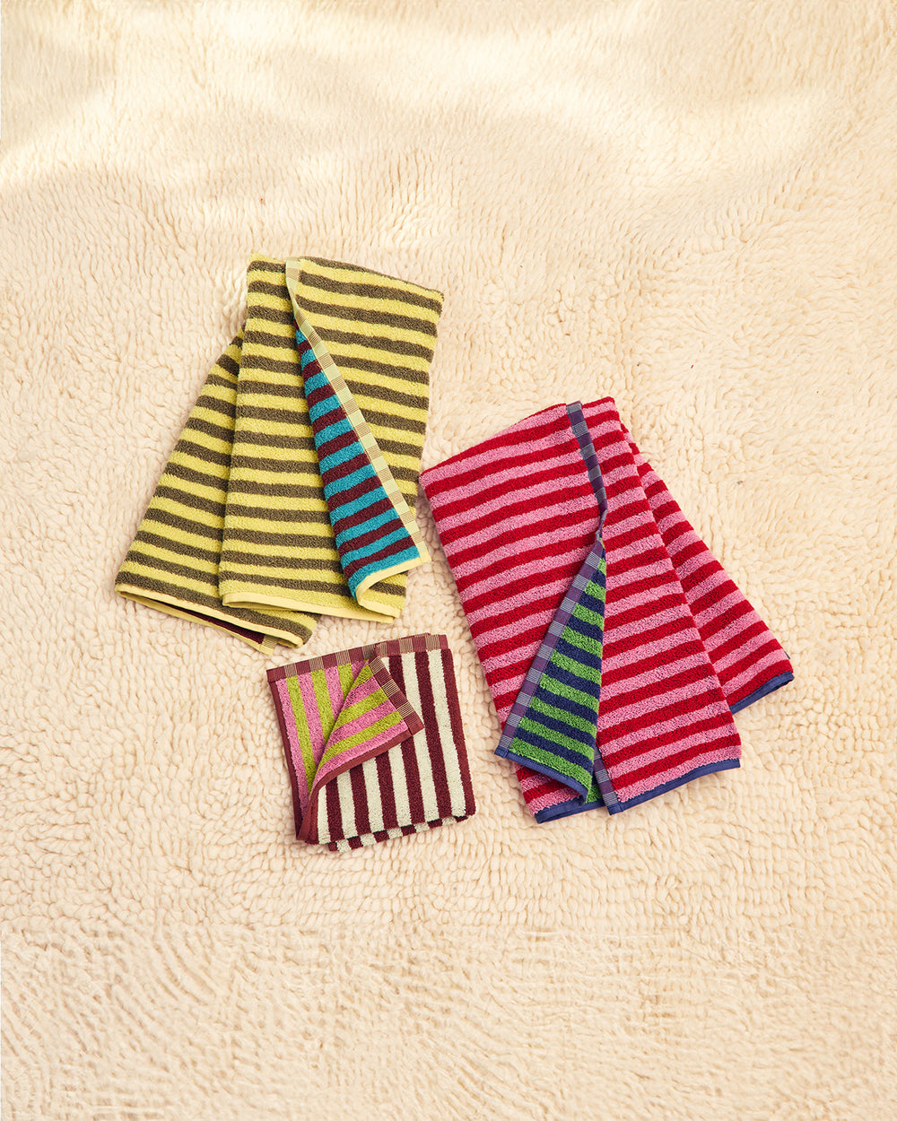 Three colorful bug towels on a carpet 