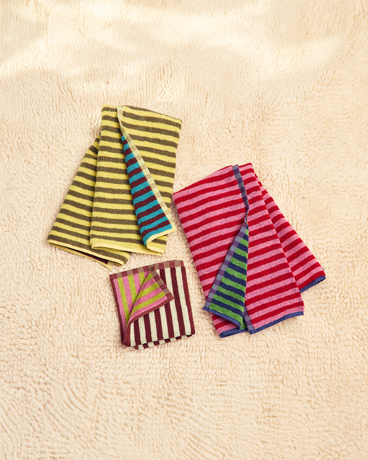 Three colorful bug towels on a carpet 