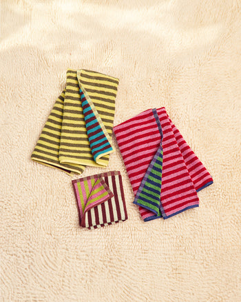 Three colorful bug towels on a carpet 