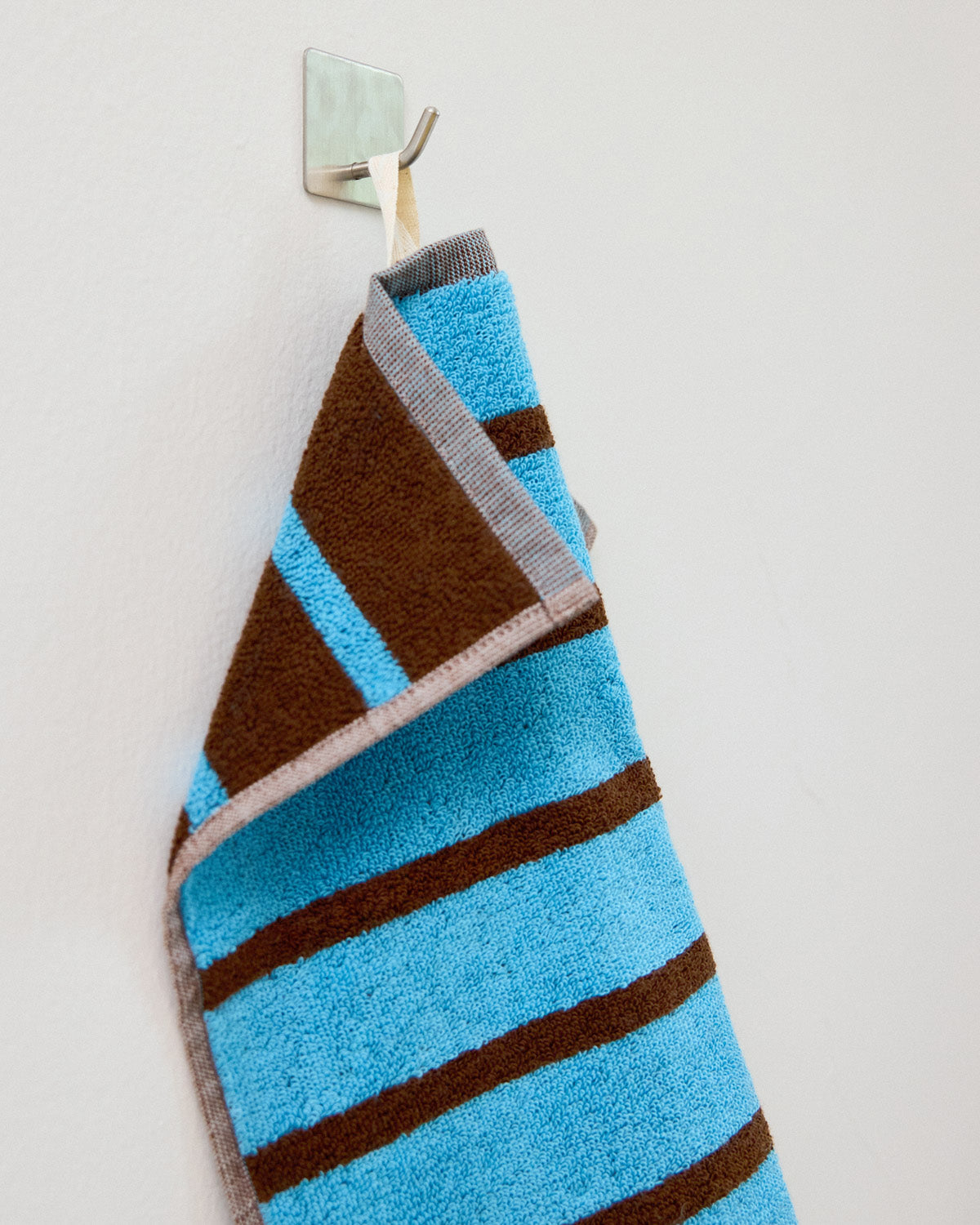 blue and brown washcloth on a hookl]
