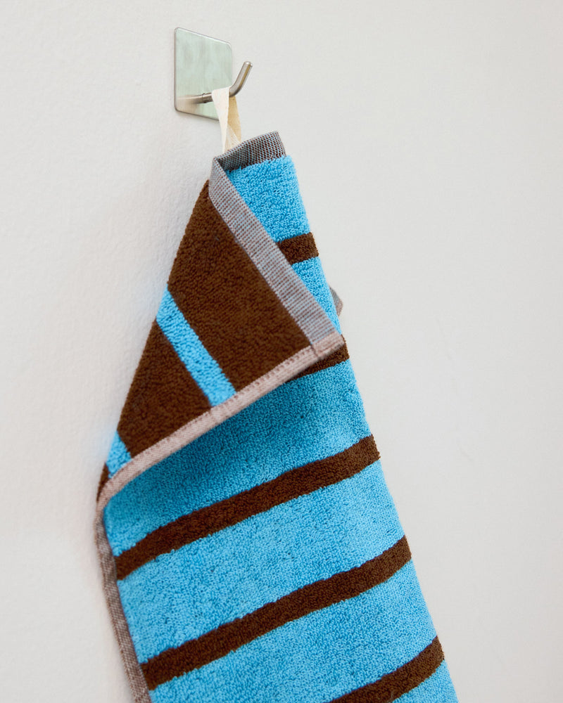 blue and brown washcloth on a hookl]