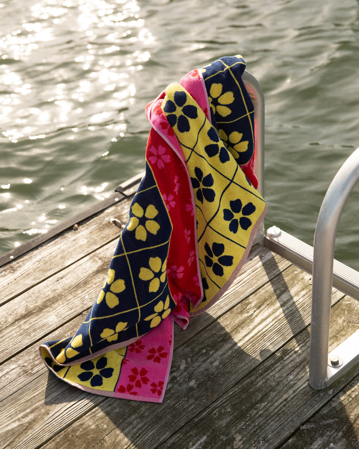 Colorful patterned towel on a wooden dock by water
