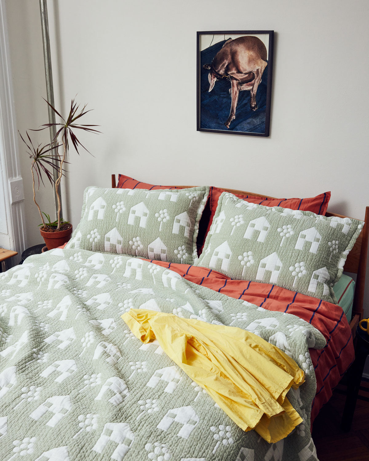 House Coverlet Coverlet in green and white with yellow shirt on bed ; Rent this coverlet out for passive income