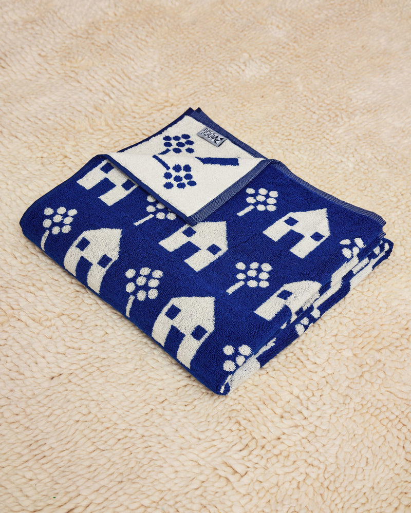 House Towel Navy and White folded on cream rug 