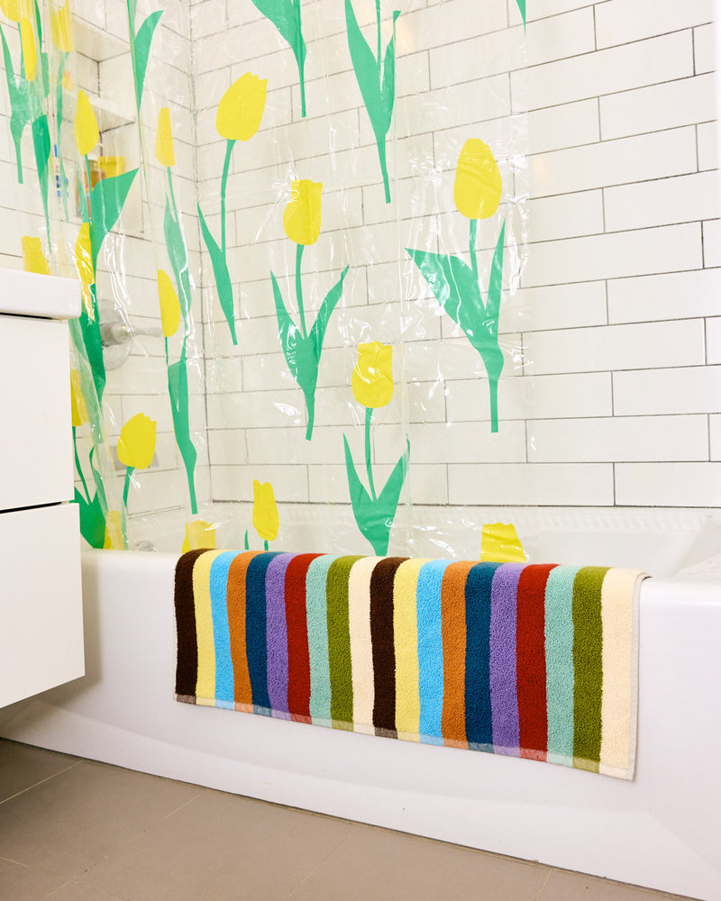 Hummingbird bath mat hanging over tub with shower curtain 