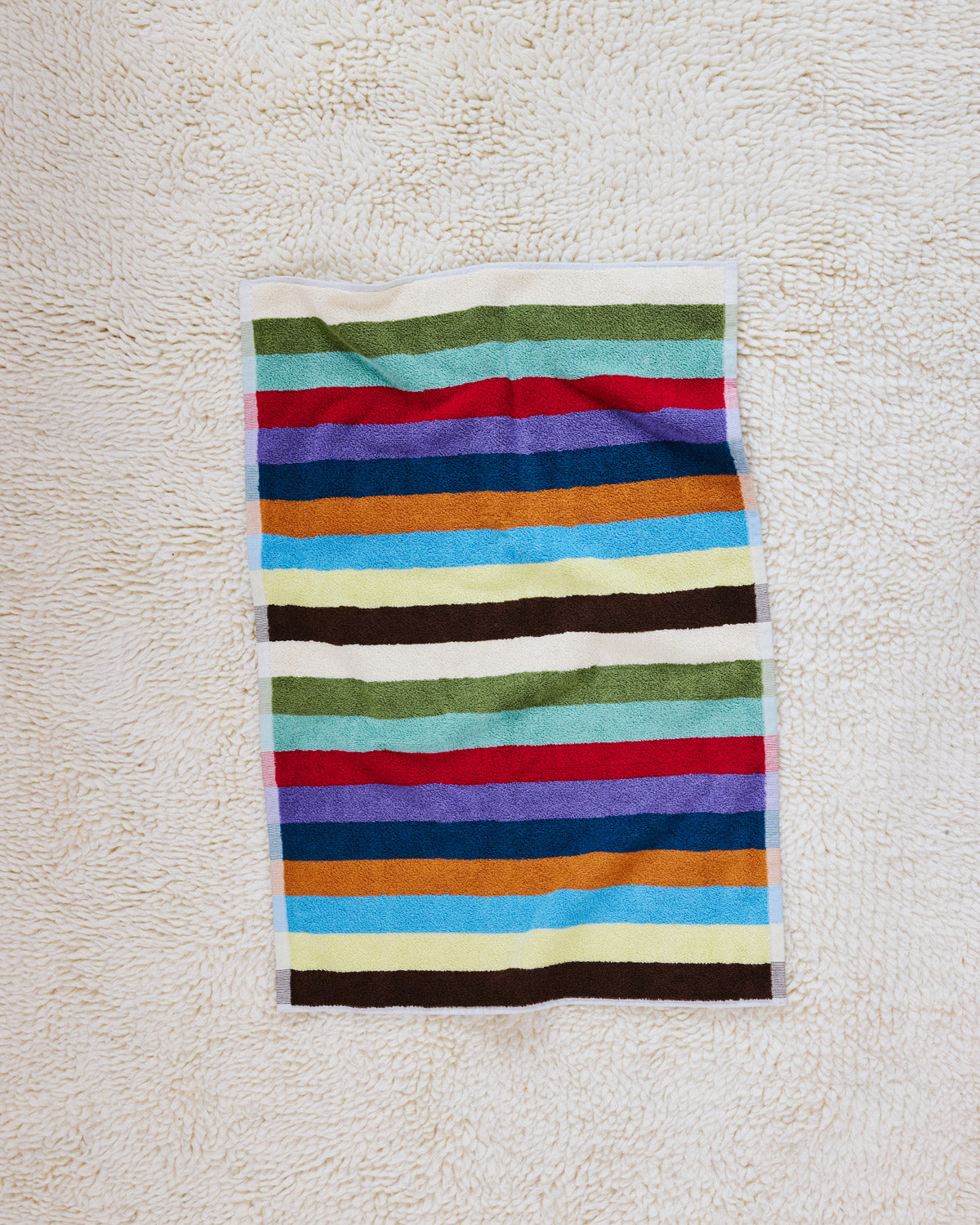 Hummingbird hand towel flat on beige carpet