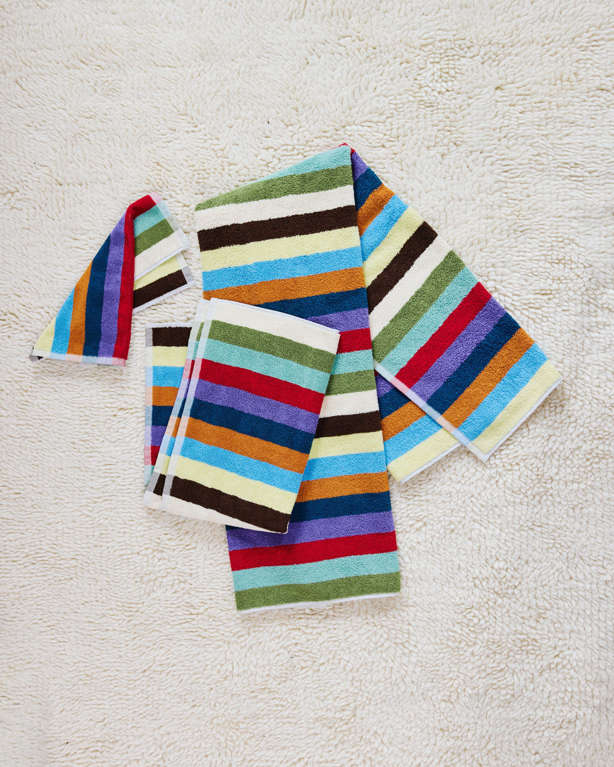 set of three hummingbird towels on a beige carpet