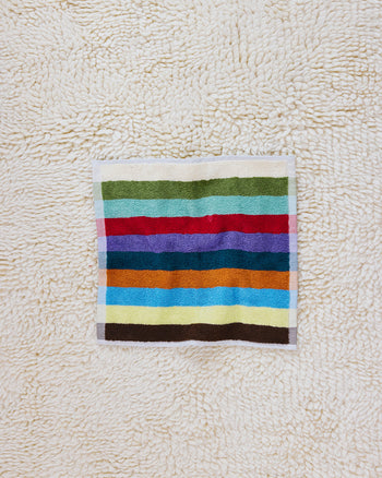 Hummingbird washcloth on beige carpet 