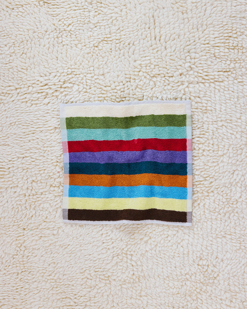 Hummingbird washcloth on beige carpet 