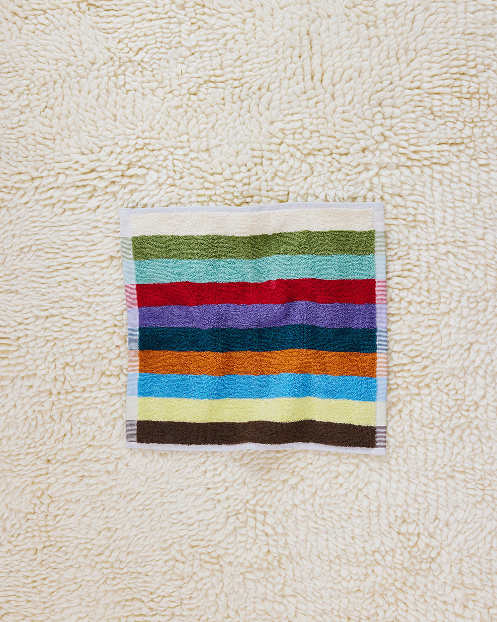 Hummingbird washcloth on beige carpet 