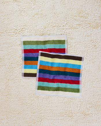 Two Hummingbird washcloths on beige carpet 