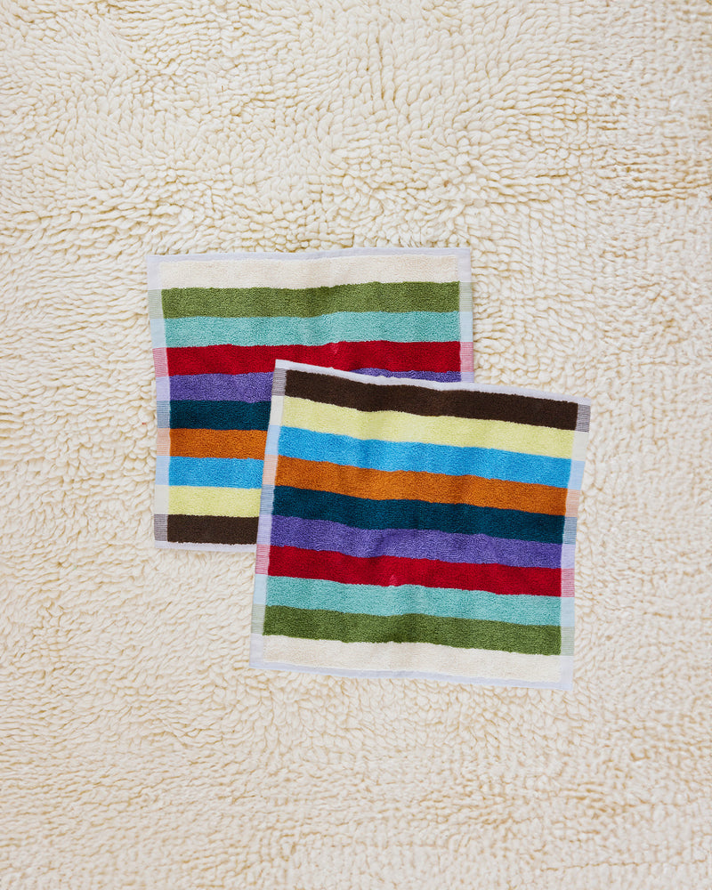 Two Hummingbird washcloths on beige carpet 