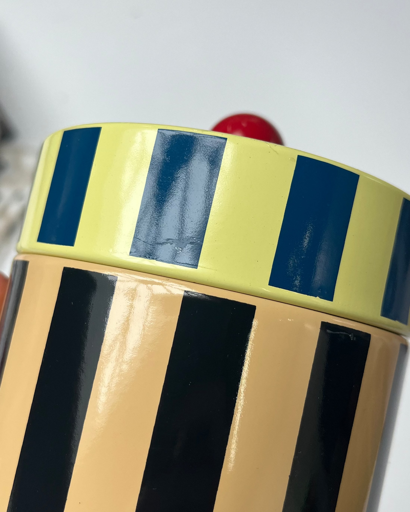 Canister stripe with light damage to lid on surface