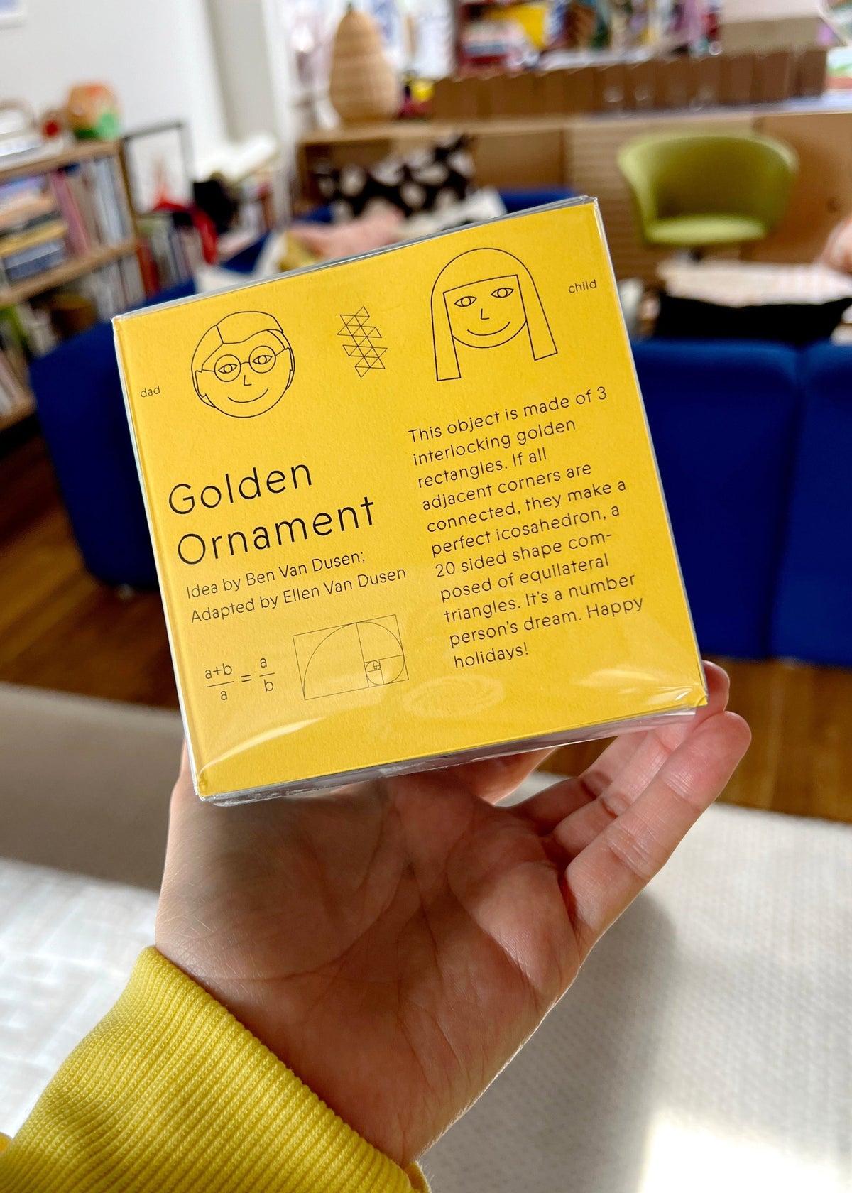 Photo of hand holding ornament box with Golden Ornament written on front