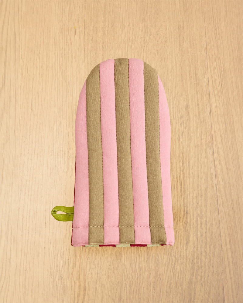 Striped pouch with pink and green stripes on a wooden surface