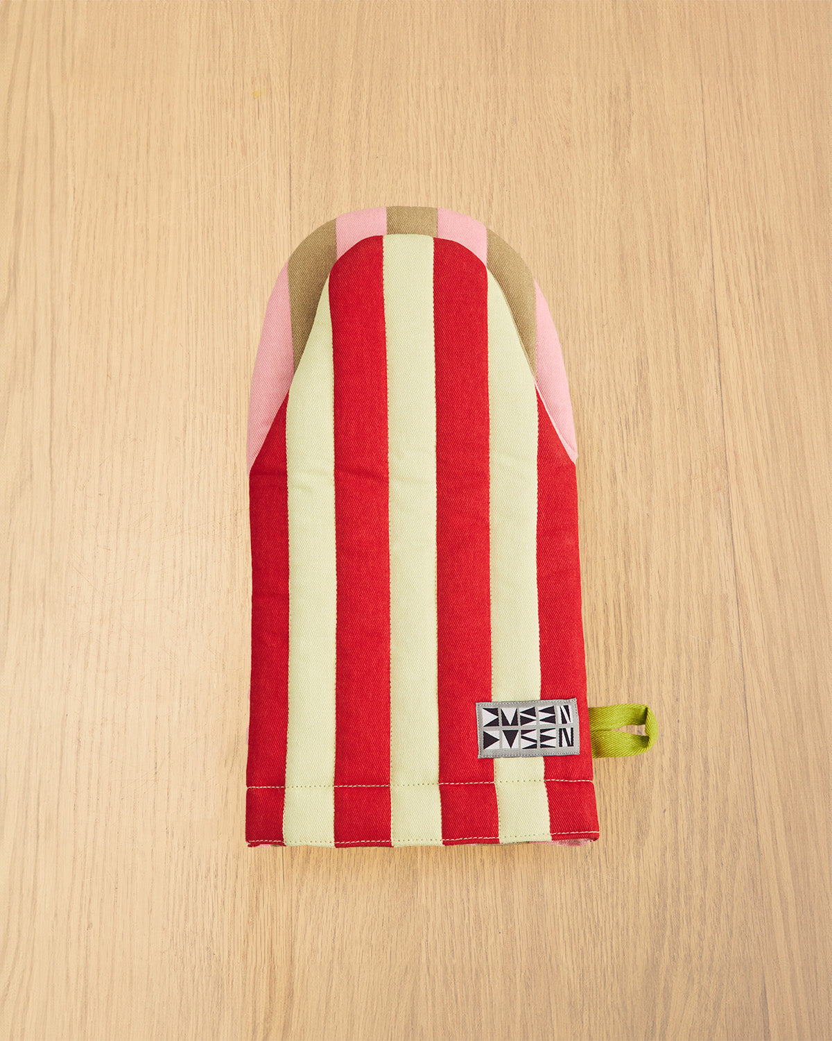 Red and white striped pouch with a visible brand label on a wooden surface